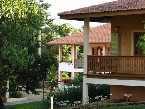 a house with a porch and a balcony at Hotel Fazenda Itáytyba in Tibagi