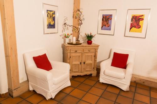 two white chairs and a cabinet in a room at Hotel Restaurant GABRIEL in Scuol