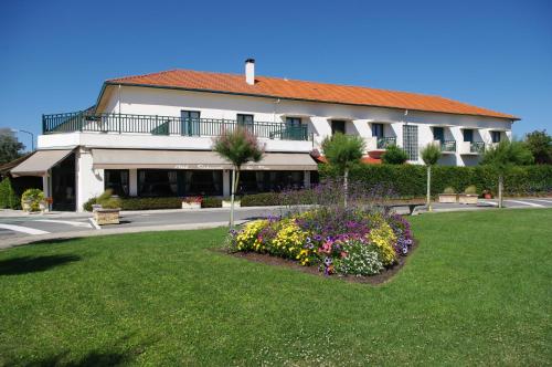 a building with a lot of flowers in front of it at Hotel des Pins in Soulac-sur-Mer
