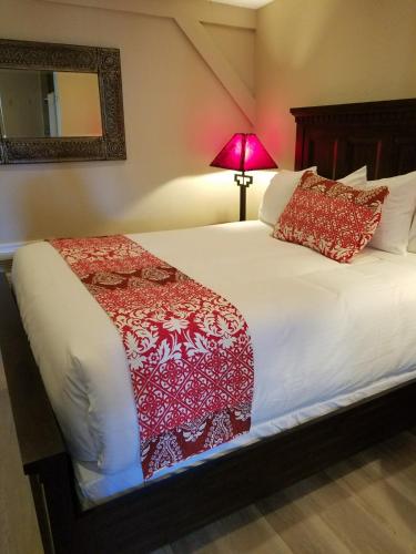 a bedroom with a bed with a red blanket on it at Lantern Light Inn - Romantic Getaway in Sedona