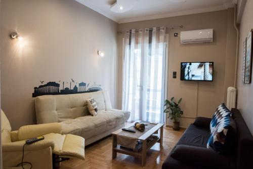 ein Wohnzimmer mit einem Sofa und einem TV in der Unterkunft Gazi Divine Apartment in Athen