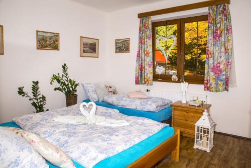 a bedroom with two beds and a window at Wellness hotel Chata Jana in Lopeník