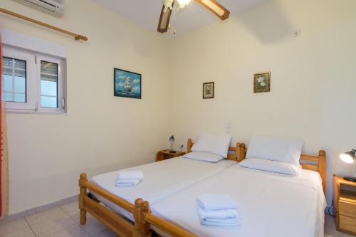 a bedroom with a large white bed with towels on it at Ikaros Villa in Makry Gialos