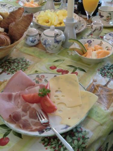 a table with a plate of cheese and other foods at B&B Au Coeur de Villers in Villers-Sainte-Gertrude