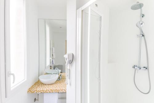 een badkamer met een wastafel en een douche bij Hotel Korner Eiffel in Parijs
