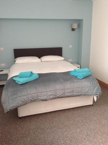 a bed with two blue towels on top of it at The Bear On The Square in Millom
