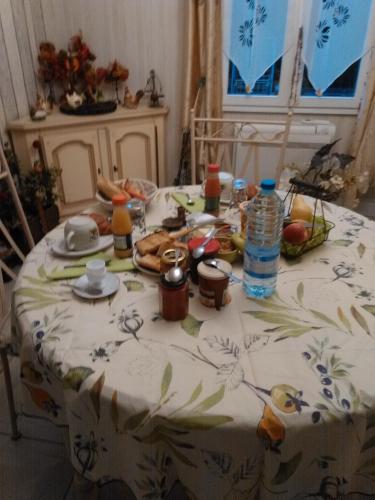 a table with a table cloth with food and water bottles at Chambre Chez l'Habitant in Ambarès-et-Lagrave