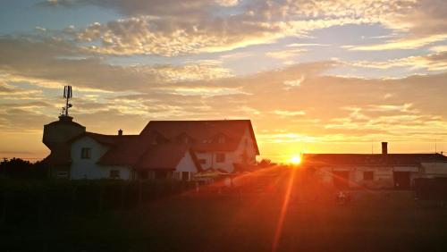 a sunset over houses with the sun setting in the background at Penzion Mušlov in Mikulov