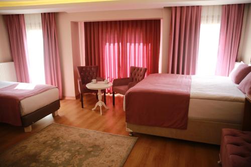a hotel room with two beds and a table and chairs at Hotel Black Pearl in Istanbul