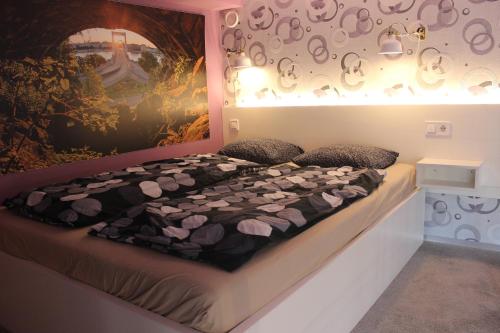 ブダペストにあるRakoczi Studiosの壁画が飾られた部屋のベッド1台