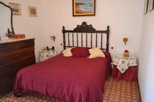 Sant Pere Sacarrera的住宿－Cal Llorenç，一间卧室配有红色的床和两张桌子