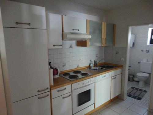 uma cozinha com um frigorífico branco e um lavatório em Ferienwohnung "Am Rothaarsteig" em Winterberg