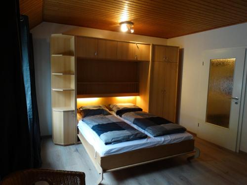 a bedroom with a large bed with a wooden headboard at Ferienwohnung "Am Rothaarsteig" in Winterberg