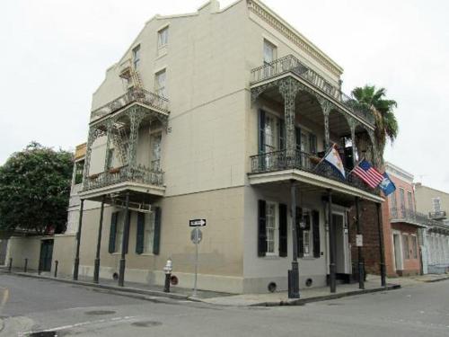 Um edifício branco com bandeiras americanas numa rua em Lafitte Hotel & Bar em Nova Orleans