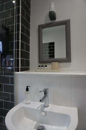 a bathroom with a white sink and a mirror at 3 Summertown Court in Oxford