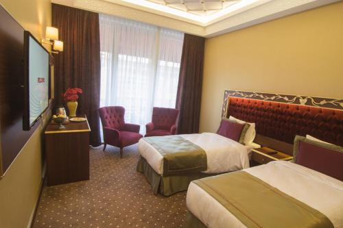 イスタンブールにあるMB Deluxe Hotelのベッド2台、薄型テレビが備わるホテルルームです。