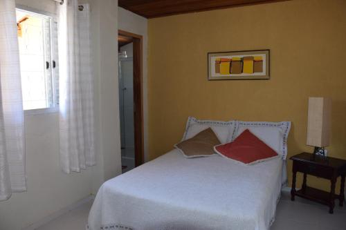 um quarto com uma cama com duas almofadas em Sitio Sao Francisco de Assis em Santo Antônio do Pinhal