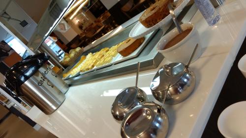 ein Buffet mit silbernen Löffeln auf einer Theke in der Unterkunft Hotel Piramide St. Antonio de Jesus in Santo Antônio de Jesus