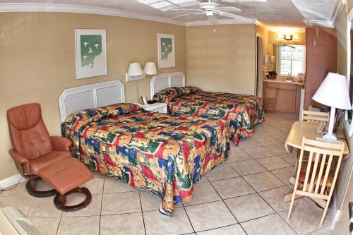 ein Hotelzimmer mit einem Bett und einem Stuhl in der Unterkunft Gulfcoast Inn Naples in Naples