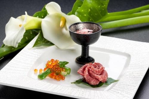 a white plate with a tablespoon of food and vegetables at Sawaemon in Chino