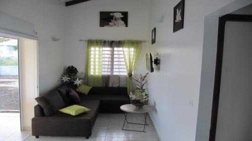 a living room with a couch and a table at Beauvalette in Sainte-Anne