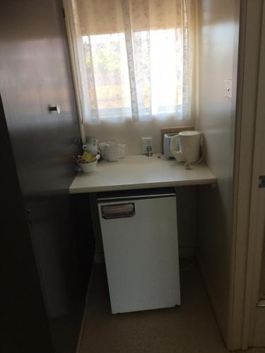 a small kitchen with a counter and a window at Yarram Commecial Hotel Motel in Yarram