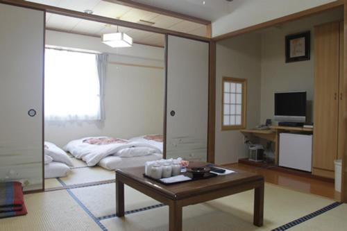 a living room with a bed and a coffee table at Hikone Station Hotel in Hikone