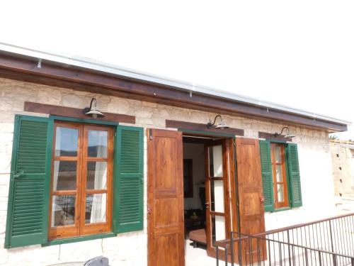 a building with green shutters and a balcony at Stou Kir Yianni in Omodos