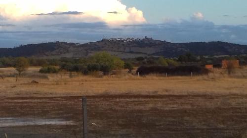 a fence in a field with a mountain in the background at Painel de Monsaraz in Reguengos de Monsaraz