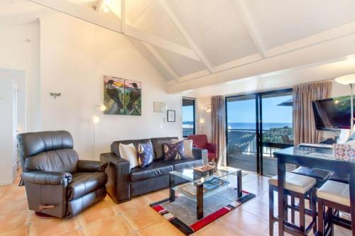 a living room with a couch and a table at Villa Topaz at Palm Beach by Waiheke Unlimited in Palm Beach