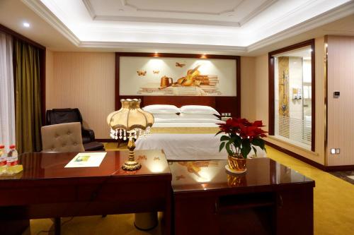 a hotel room with a bed and a desk at 维也纳国际酒店上海浦东机场自贸区店一免费提供浦东机场和迪士尼班车接送 in Shanghai