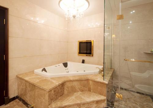 W łazience znajduje się wanna i przeszklony prysznic. w obiekcie President Hotel w Guangzhou