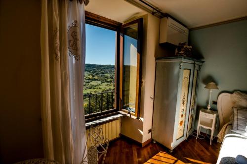 a bedroom with a large window with a view at Ripa Medici, camere con vista e parcheggio incluso in Orvieto