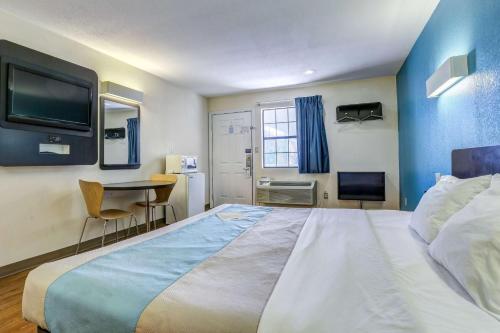 una habitación de hotel con una cama grande y una mesa en Motel 6-Dickson, TN, en Dickson