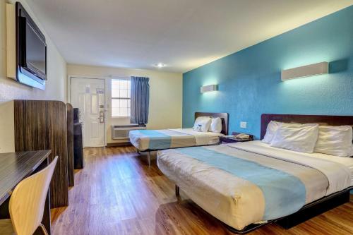 a hotel room with two beds and a blue wall at Motel 6-Dickson, TN in Dickson