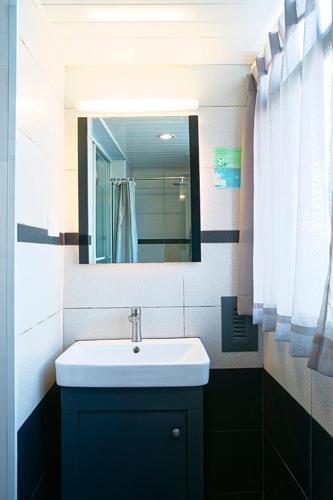 a bathroom with a sink and a mirror at Kunming Upland International Youth Hostel ,near the city center ,2 mins walk to the subway, 2 mins walk to the Green Lake, Close to Yuan tong Temple, Old street, Yunnan University, convenient payment and visa cards are accepted in Kunming