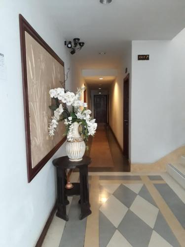 a vase with flowers on a table in a hallway at Charming Lao Hotel in Ban Chéng
