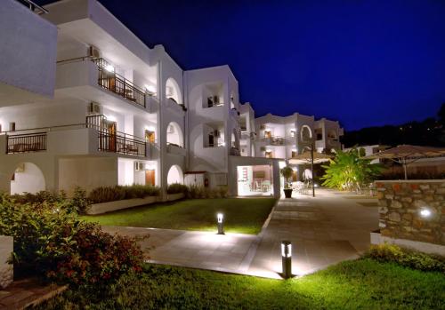 - un grand bâtiment blanc avec des lumières dans la cour dans l'établissement Hotel Korali, à Troulos