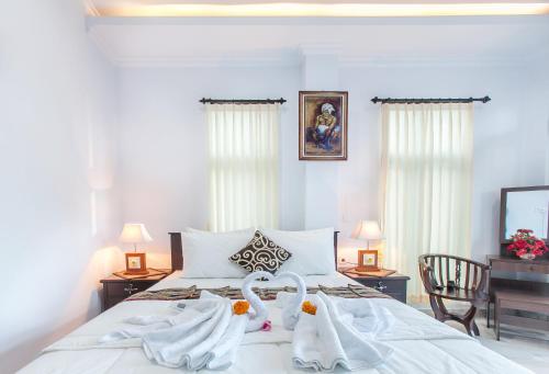 a bedroom with a bed with two towels on it at Yoga's House in Ubud