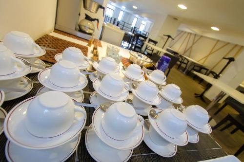 a group of white cups and saucers on a table at Imperial Hotel Express in Kisumu