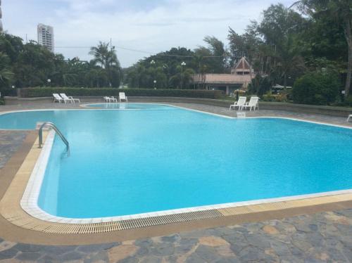 a large blue swimming pool with chairs around it at Vip condo chain by Linda in Ban Phe