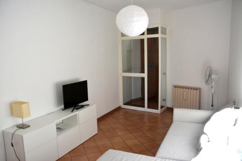 uma sala de estar com um sofá branco e uma televisão em Palazzo Calocci appartamenti in Assisi em Assis