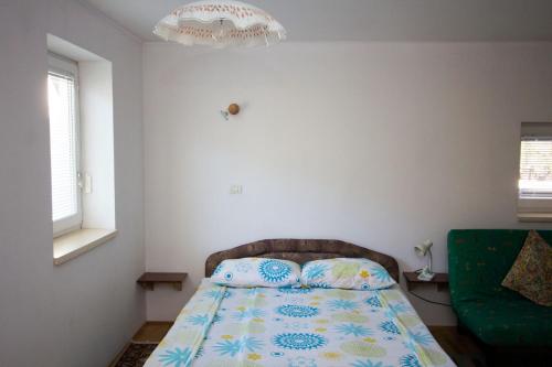 a bedroom with a bed and a green couch at Apartment Mavrica in Bovec