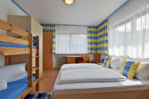 カルテンバッハにあるFerienwohnungen Hauserのベッドルーム1室(二段ベッド2組、デスク付)