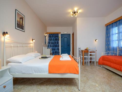 Un dormitorio con una cama con una manta naranja. en Studios Sofia Dream, en Agia Anna de Naxos
