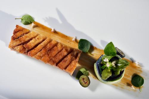 a white plate with some food on a white table at Mercure Petriolo Siena Terme Spa Hotel in Bagni di Petriolo
