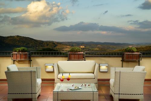 a living room filled with furniture and a balcony at Mercure Petriolo Siena Terme Spa Hotel in Terme di Petriolo