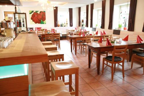a restaurant with wooden tables and chairs with red napkins on them at Il Plonner - Hotel Restaurant Biergarten in Weßling