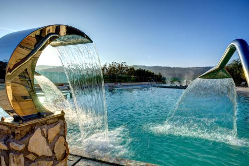 a water fountain in a swimming pool at Mercure Petriolo Siena Terme Spa Hotel in Bagni di Petriolo