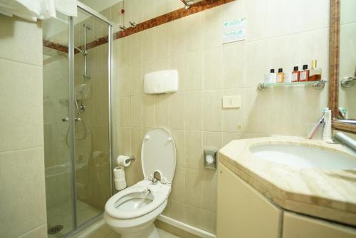 e bagno con servizi igienici, lavandino e doccia. di Le Cale D'Otranto Beach Resort a Otranto
